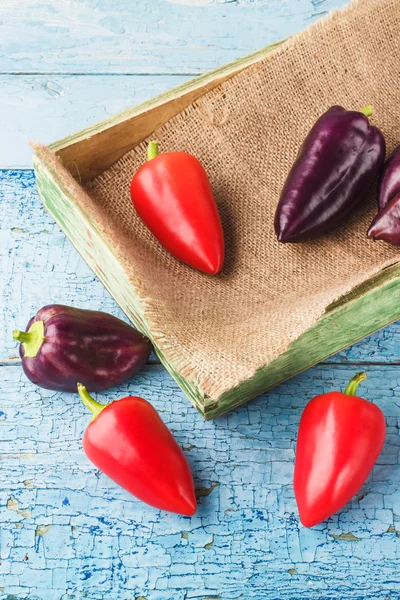 Gekleurde paprika's in de houten lade — Stockfoto