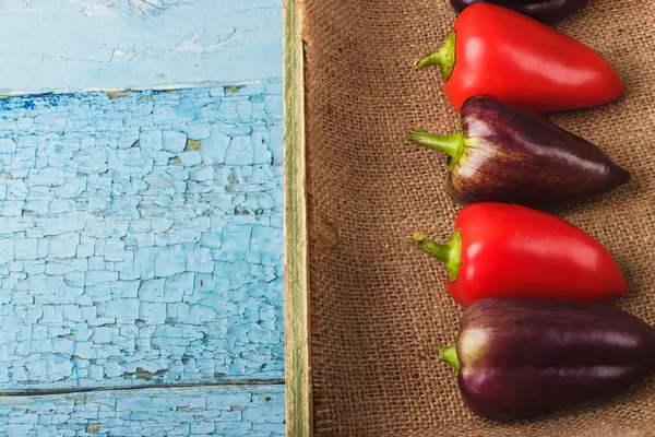 Gekleurde paprika's in de houten lade — Stockfoto
