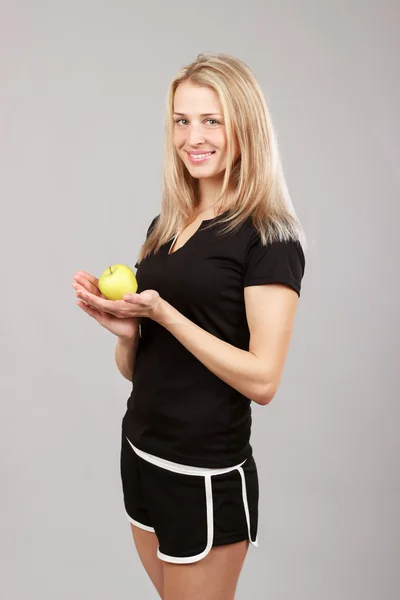 Красивая атлетичная девушка с яблоком в руках — стоковое фото