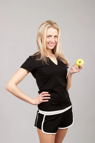 Beautiful athletic girl holding an apple — ストック写真