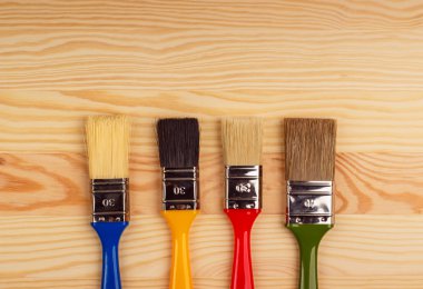 Ahşap arka plan üzerinde tamir için renkli fırça seti