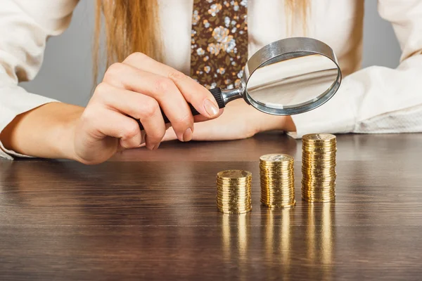 Büyüteç'i ve sikke yığını ile kadının el