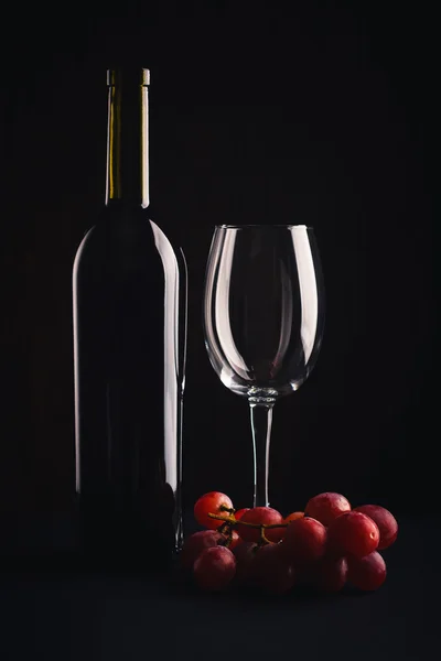 Butelka czerwonego wina, szkło i kiść winogron — Zdjęcie stockowe