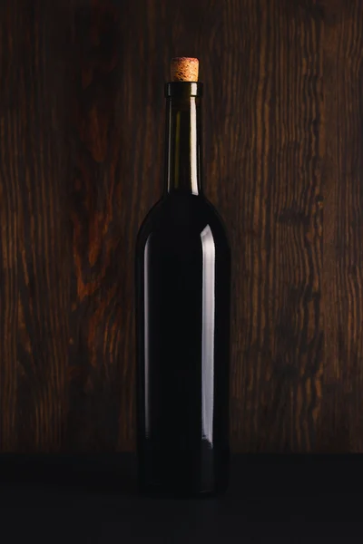 Glasflasche Wein auf schwarzem Hintergrund — Stockfoto