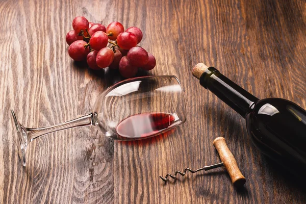Glas med vin, korkskruv, flaska och druvor — Stockfoto