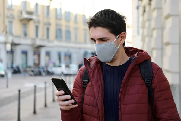 Kaukaski Mężczyzna Noszący Maskę Twarzy Przy Użyciu Telefonu Komórkowego Podczas — Zdjęcie stockowe