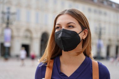 Korumacı bir KN95 FFP2 siyah maske takan öğrenci portresi