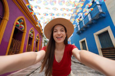 Brezilya 'daki karnaval için renkli şemsiyelerle dolu tarihi Olinda kasabasındaki genç bir kadının portresi.