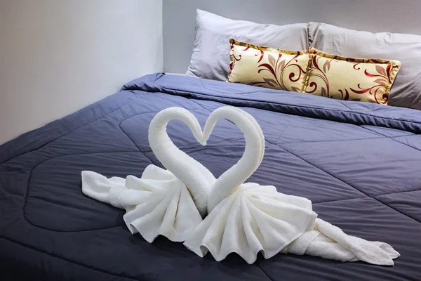 Towel folded in swan shape on bed sheet — Stock Photo, Image