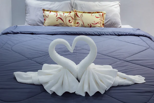Serviette pliée en forme de cygne sur drap de lit — Photo