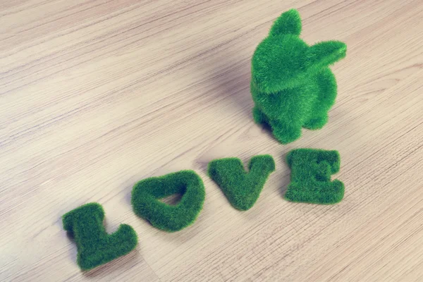 Green love wording and little rabbit on wooden floor, made from — Stock Photo, Image