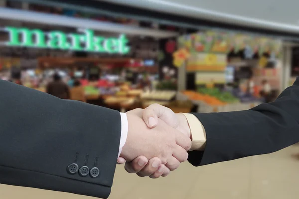 Business handshake z rozmycie tła rynku handlowego — Zdjęcie stockowe