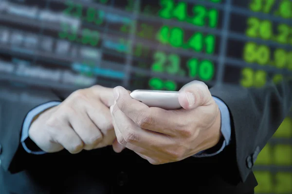 Businessman touch smart phone in hand with exchange rate blur ba — Stock Photo, Image