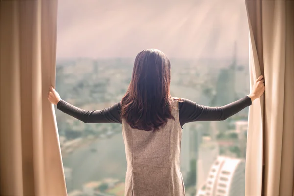 Asiático retrato bela mulher abertura cortinas e construção cit — Fotografia de Stock