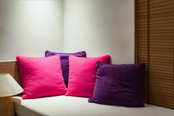 Πολύχρωμα μαξιλάρια στην γωνία του καναπέ στο υπνοδωμάτιο — Φωτογραφία Αρχείου