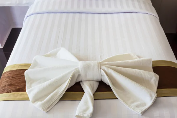 Yatakta yay şeklinde beyaz havlu katlanmış — Stok fotoğraf