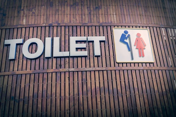 Homme et une dame signe de toilette sur fond de bois — Photo