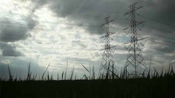 Elektrik direği, yüksek gerilim kuleleri ve gökyüzü günbatımı pirinç yeşil dolly atış under — Stok video