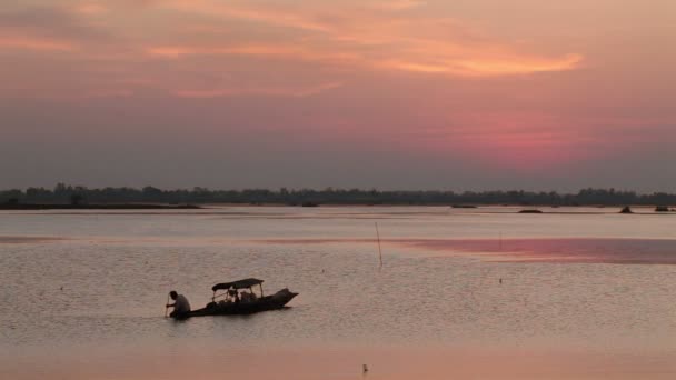 Silhouette of fisherman and boat in pond or lake at sunset — Stock Video