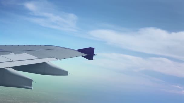 Ala de um avião voando acima das nuvens, disparado da janela do avião — Vídeo de Stock
