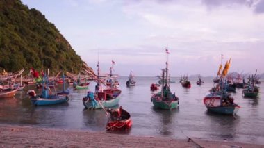 Tayland Pranburi plajda demirlemiş balıkçı teknesi grubu, alacakaranlık günbatımı sahne alınan