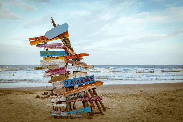 Señal de tráfico de viaje palo en madera o carpa de hoguera en la playa de arena —  Fotos de Stock