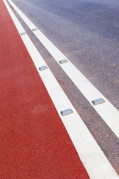 Parafuso prisioneiro de estrada com refletor branco e caminho vermelho — Fotografia de Stock