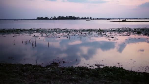 Naplemente és a háttér ég, a folyó vagy tó a szürkületben idő, kamera panoráma dönthető lövés — Stock videók