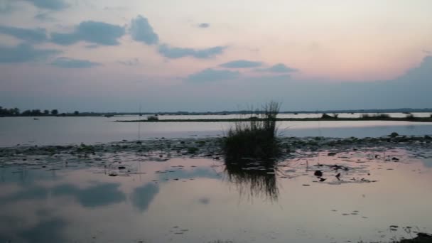 Puesta del sol y el fondo del cielo, en el río o lago y la casa de inundación en el suelo en el crepúsculo, cámara panorámica disparo — Vídeos de Stock