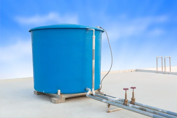 Blauwe watertank van industrieel gebouw op het dak en blauw clou — Stockfoto