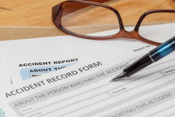 Accident report application form and pen on brown envelope and e — Stock Photo, Image