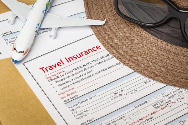 Formulário de pedido de seguro de viagem e chapéu com óculos em — Fotografia de Stock