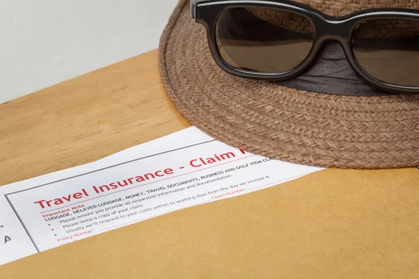 Travel Insurance Claim application form and hat with eyeglass on — Stock Photo, Image