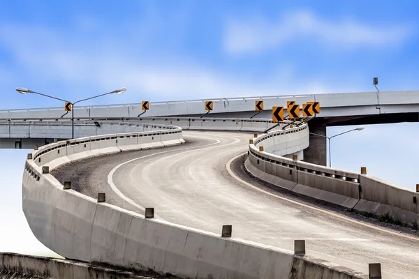 Carretera asfalto carretera curva y señal de tráfico con cielo azul backgr — Foto de Stock