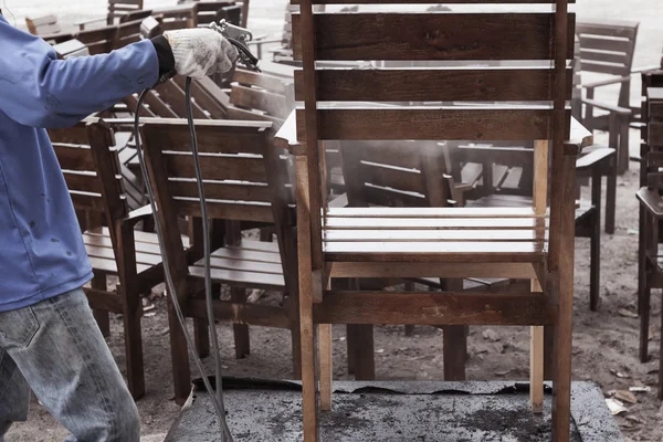 Рабочий или плотник, покрашенный или отремонтированный брызг руки, деревянный стул — стоковое фото