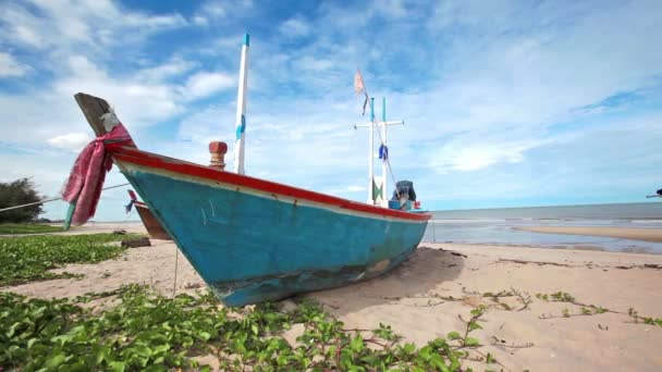 Barca da pesca sulla spiaggia di sabbia e sfondo cielo blu in HD, dolly tracking camera girato al momento della luce del giorno, angolo basso — Video Stock