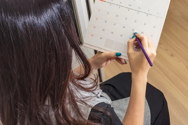 Kvinna med penna på kalendern för att göra utnämning import — Stockfoto