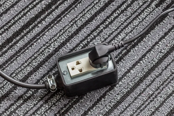 Electrical socket with power plug cable on carpet floor for safe — Stock Photo, Image