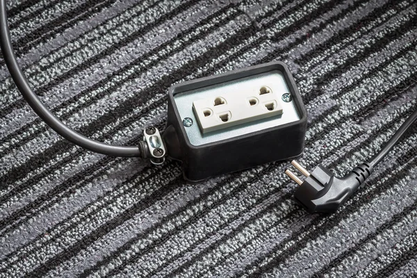 Electrical socket with power plug cable on carpet floor for safe — Stock Photo, Image