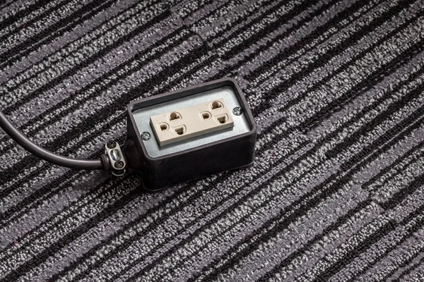 Elektrické zásuvky s napájecí kabel na podlaze koberec pro bezpečné — Stock fotografie