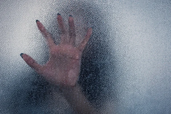 Halloween mano femenina detrás de fondo de vidrio transparente como sil — Foto de Stock