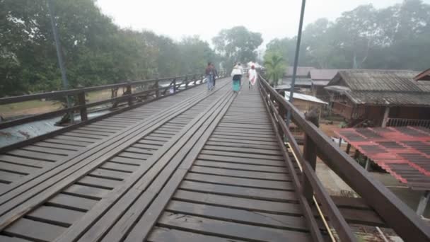 SANGKHLABURI, THAÏLANDE - 27 DÉCEMBRE 2015 : foule de voyageurs marchant sur le pont Sapan Mon, pont en bois traversant la rivière le matin dans le district de Sangkhlaburi, Kanchanaburi Thaïlande, le 27 décembre 2015 — Video