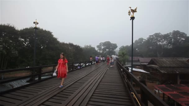 SANGKHLABURI, THAILAND - DECEMBER 27, 2015: Traveler crowd walking on Sapan Mon Bridge, wooden bridge across the river in morning in Sangkhlaburi District, Kanchanaburi Thailand,on December 27, 2015 — Stock Video