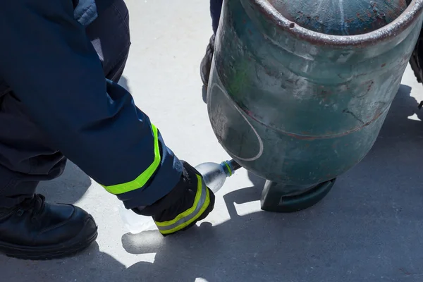 Entraîneur d'incendie, versant le gaz liquide de GPL dans la bouteille par la tête en bas — Photo