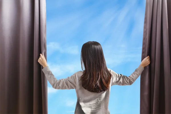 Asian portrait beautiful woman opening curtains on cloud sky bac