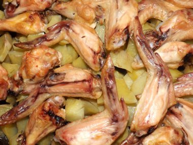 Kızarmış tavuk kanadı ve patatesler yakın plan..