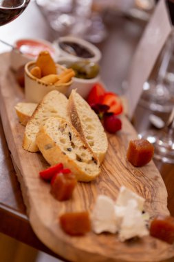 Peynir tabağı. Cevizli peynir ve ahşap masada bal. Tahta tabakta tadımlık yemek. Şarap için yiyecek..