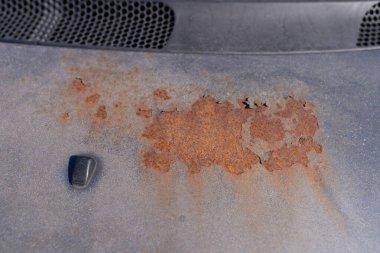 Arabanın paslı kaputu çürümüş, demire yapışmış.