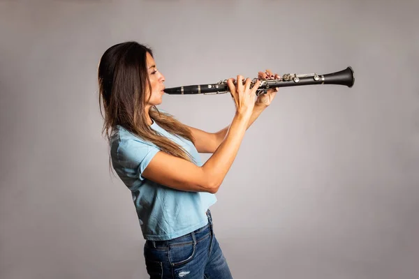 Donna Che Suona Clarinetto Uno Sfondo Grigio — Foto Stock