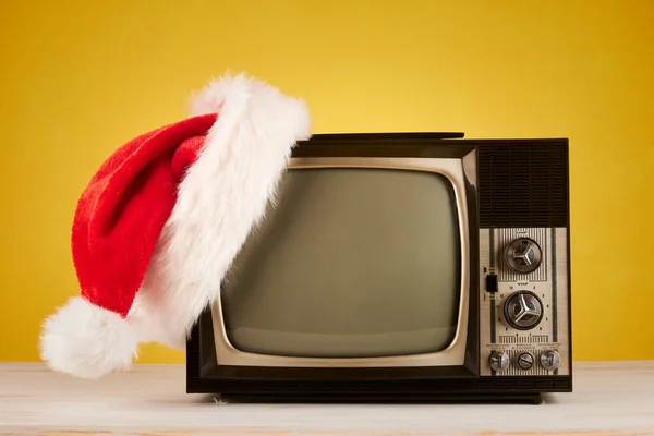 Sarı Arka Planda Noel Şapkası Olan Retro Televizyon — Stok fotoğraf